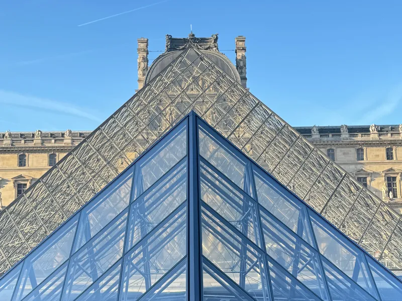 The Louvre's glass pyramid shot from below, in front of the palace wing